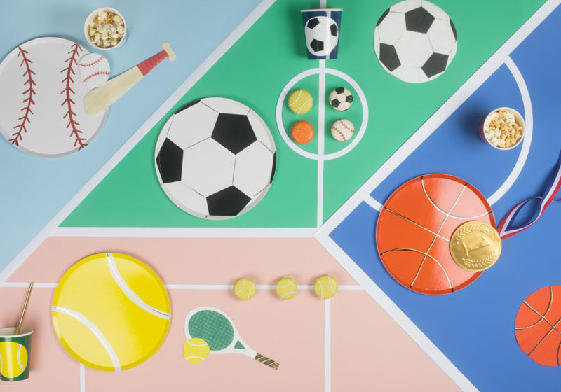 Bright sports party backdrop with oversized soccer ball basketball and tennis gear on a multicolored court