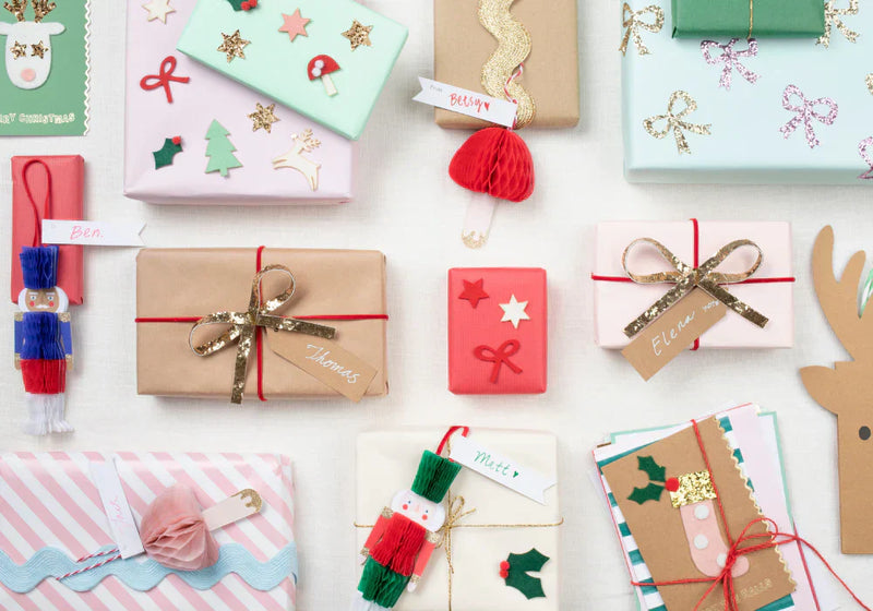 Pastel wrapped Christmas gifts with ribbons and handmade gift tags