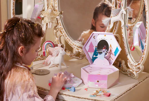 Girl at a vintage vanity surrounded by pastel advent calendar boxes and ornaments.
