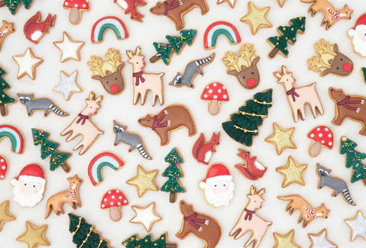 Assorted Christmas shaped cookies with colorful icing and decorations laid out on a light surface