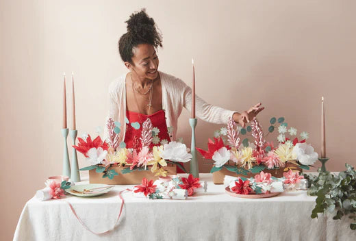 Hazel Gardiner arranging a festive floral centerpiece with candles and garlands