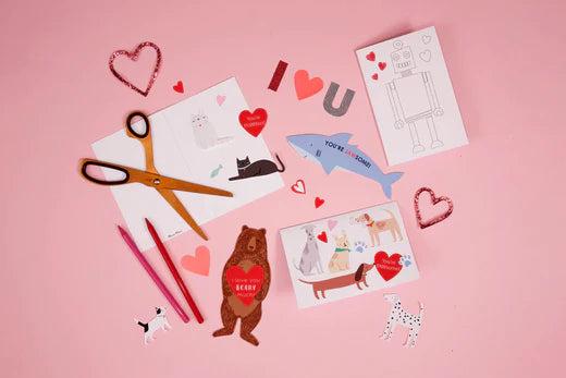 A pink background features Valentine's cards, including designs of a bear, shark, cats, a robot and dogs.