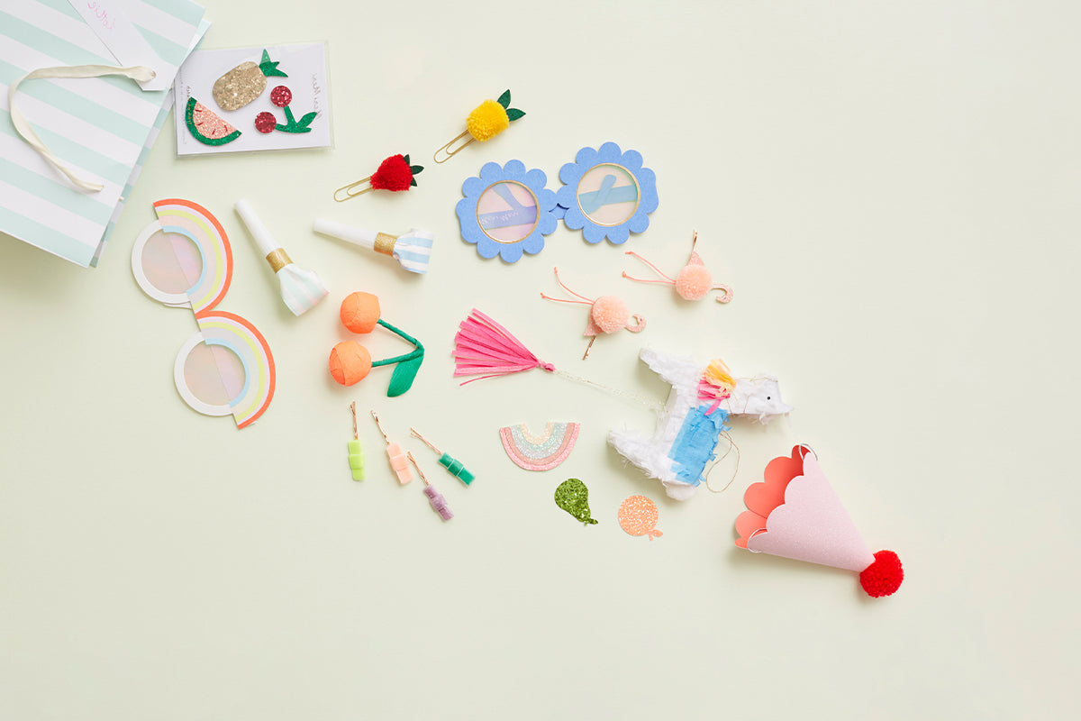 A scattering of party favors, including paper clips, hair slides, and mini piñatas.