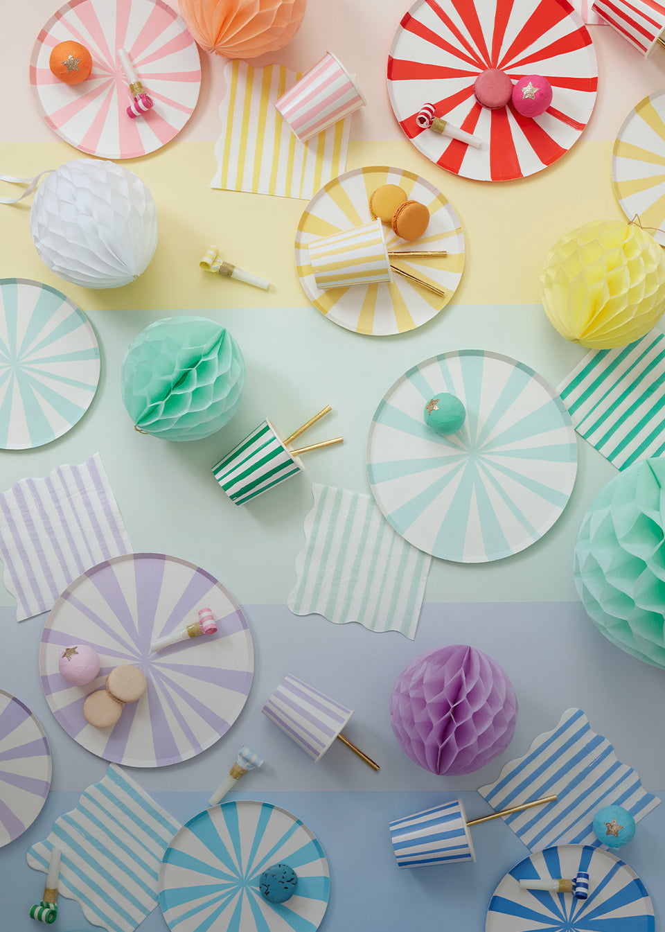 A rainbow display of pinwheel stripe plates, cups, and napkins.