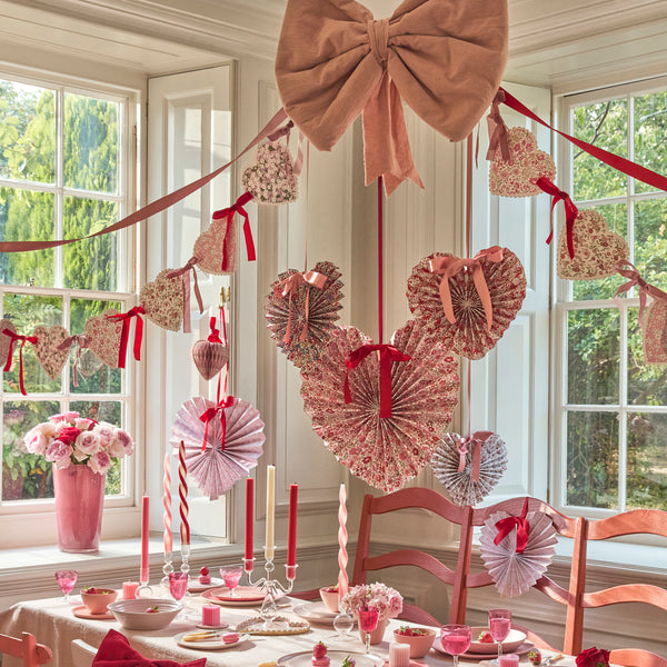 Our Valentine's Day garland feature paper hearts with floral Liberty print designs and pink and red luxe velvet bows. Image2