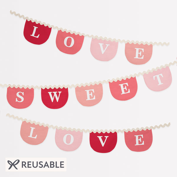 Our Valentine's decoration, a fabric garland, has scalloped pennants in red and pink with a romantic message. Image1