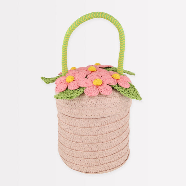 Our woven paper pink basket bag features paper flowers and leaves, a cord handle and a calico lining.