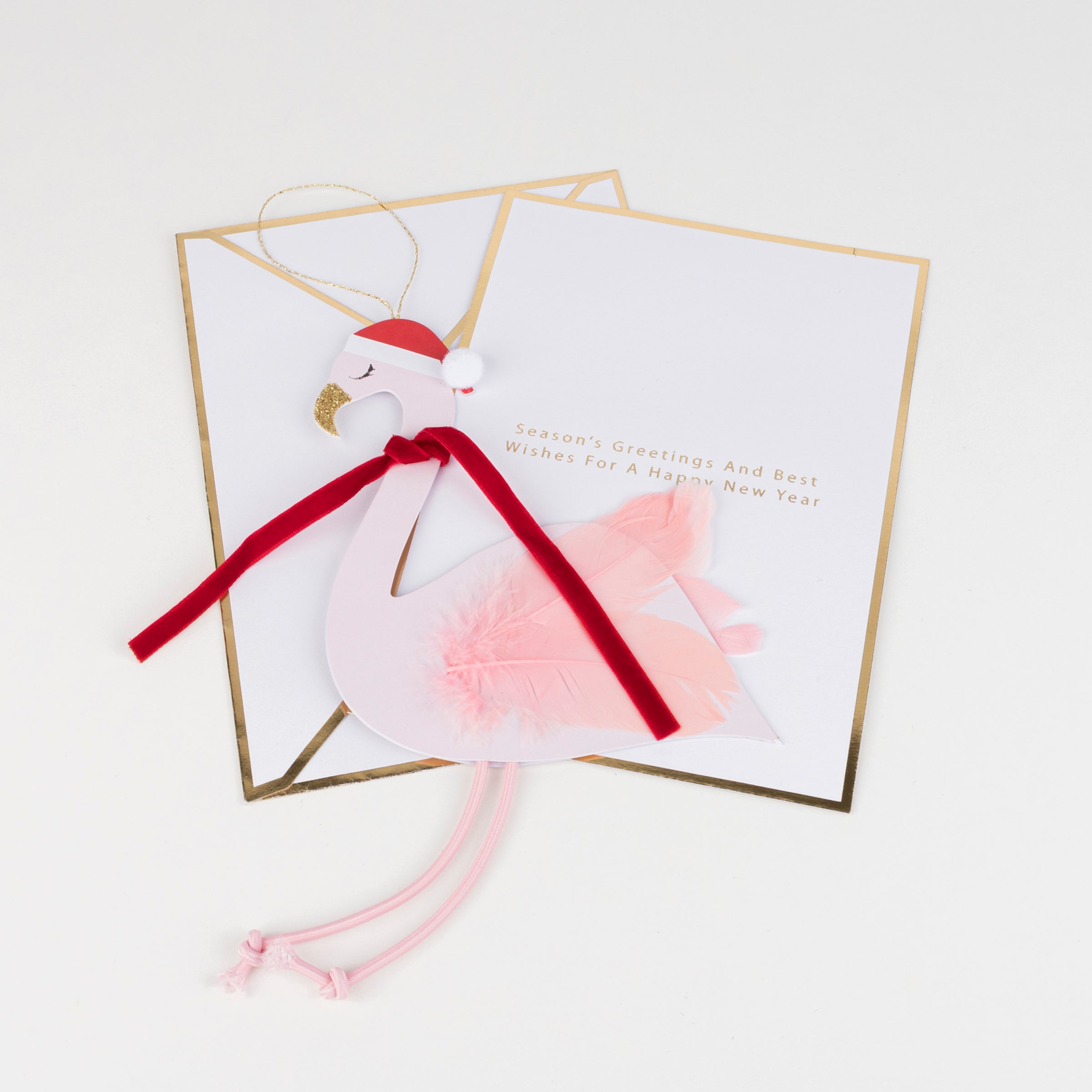 This wonderful card doubles up as a flamingo Christmas decoration, with a pompom, velvet ribbon, pink feathers and pink cord details.