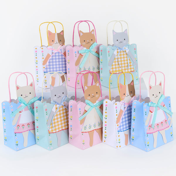 Our special paper gift bags feature adorable kittens in folk-inspired outfits with pretty ribbon bow embellishments, ideal for birthday parties. Image1