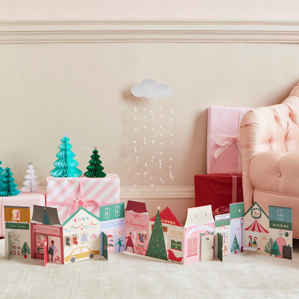 Our paper advent calendar is designed to look like Christmas street scene, with festive illustrations behind the windows and doors.