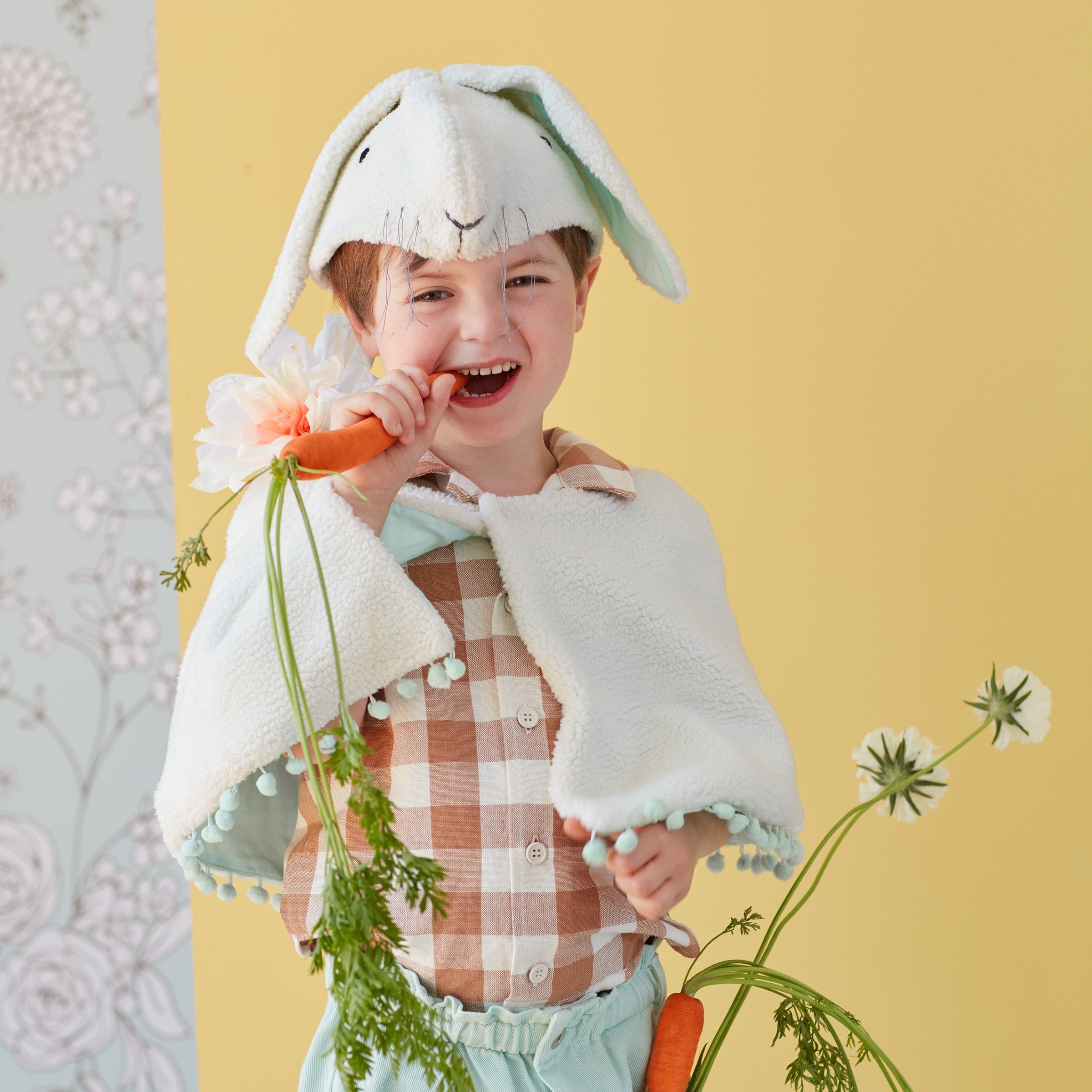 This bunny costumes features a cape and head dress crafted from soft fleece, with embroidered details and a mint lining.