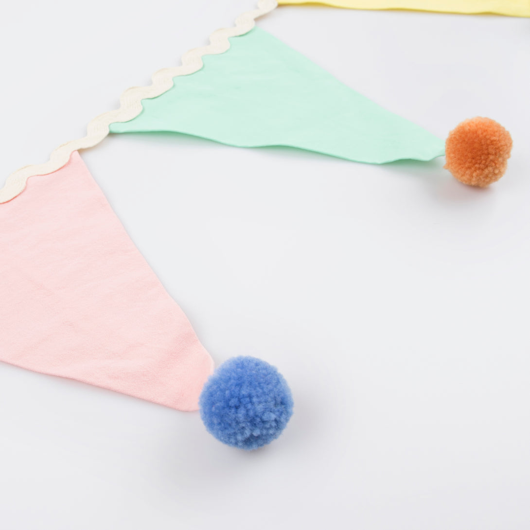 Add a pop of pastel colour to your party table or wall with our flag garland with pompoms.