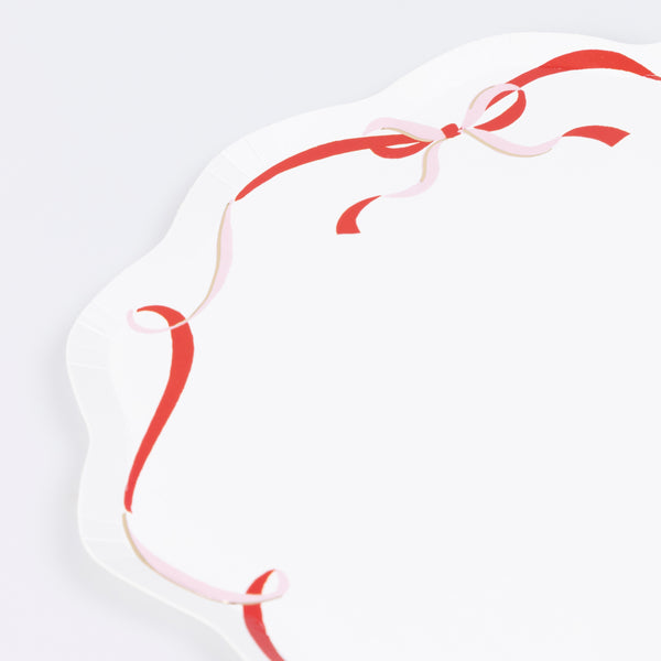 Our paper Christmas dinner plates feature a pink, red and gold modern bow design. Image3