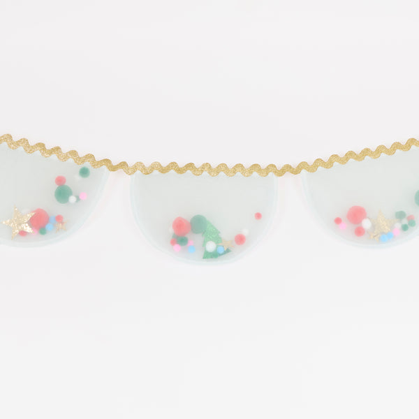 Our Christmas garland features white organza pennants filled with pompoms and glitter fabric stars and Christmas trees, with a ric rac trim. Image2