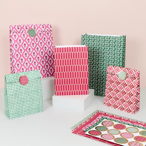 Our Christmas gift bags, made from premium paper, feature a set of 10 with Molly Mahon block print designs in shades of red, pink and white. Image1