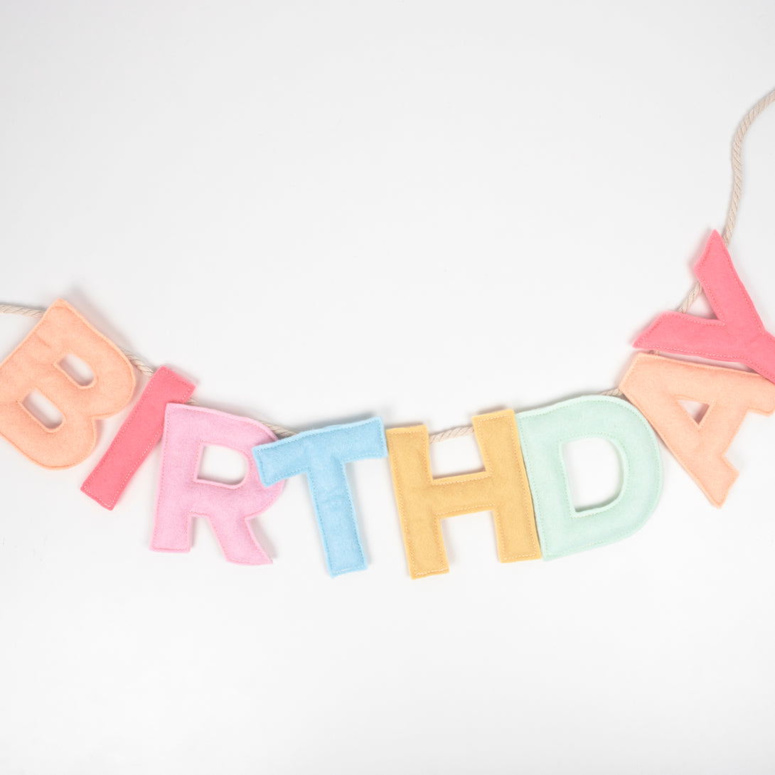 Add a rainbow of colour to your birthday party supplies with a colourful felt garland, paper tablecloth and bright birthday cake candles. 
