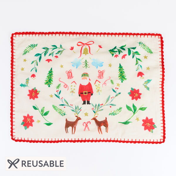 Our Christmas placemats, made from a linen and cotton mix, feature Santa in a folk-inspired scene, with gold embroidery and a crochet trim. Image1