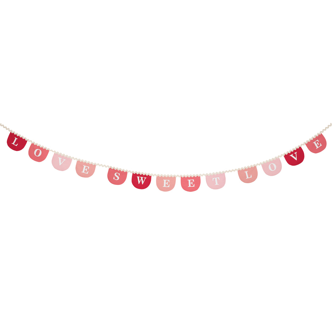 Our Valentine's decoration, a fabric garland, has scalloped pennants in red and pink with a romantic message.