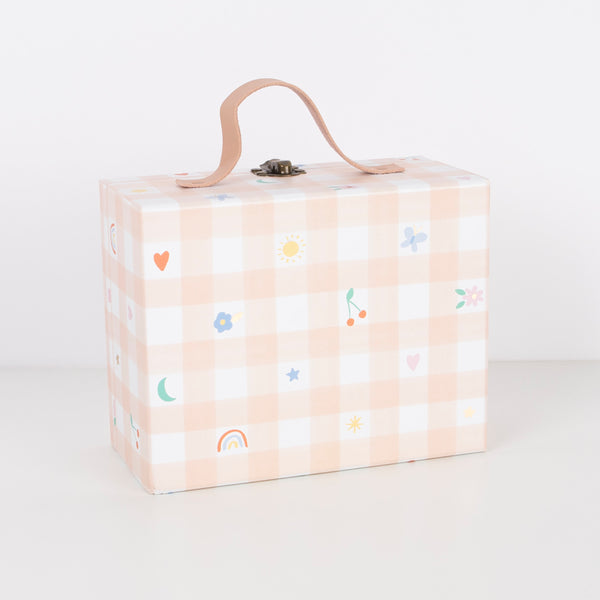 The pink gingham mini suitcase opens to reveal numbered trays filled with enamel charms, tassels and a gold tone necklace. Image5