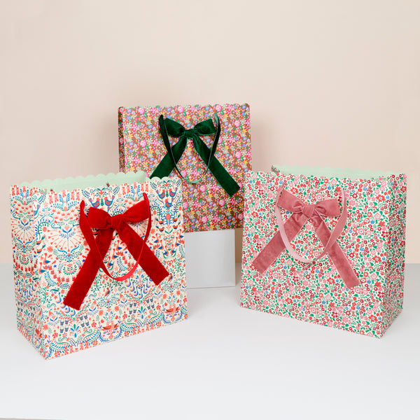 Our large paper Christmas gift bags feature Liberty print designs for an elegant look, with three designs, velvet ribbon bows and handles. Image1