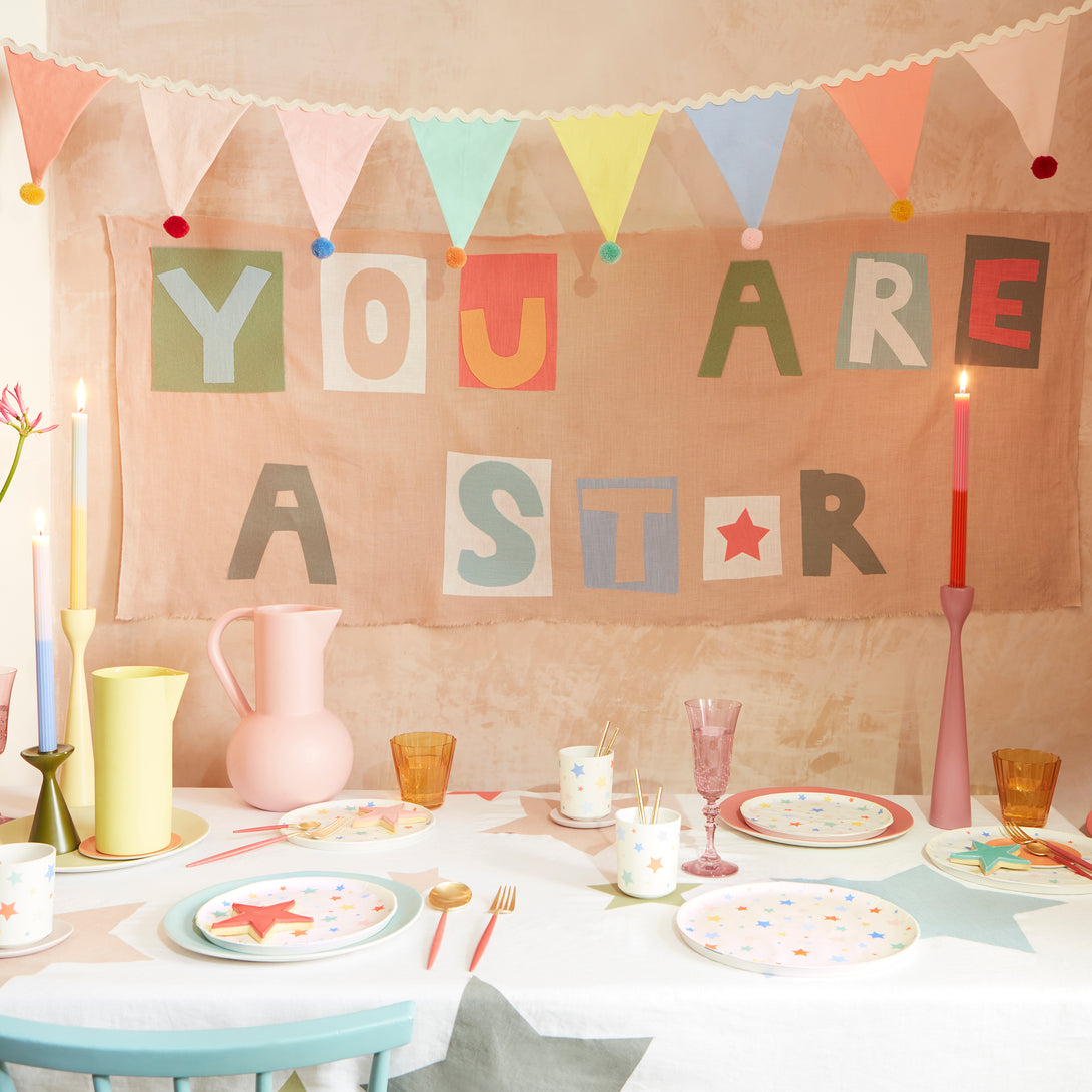 Add a pop of pastel colour to your party table or wall with our flag garland with pompoms.