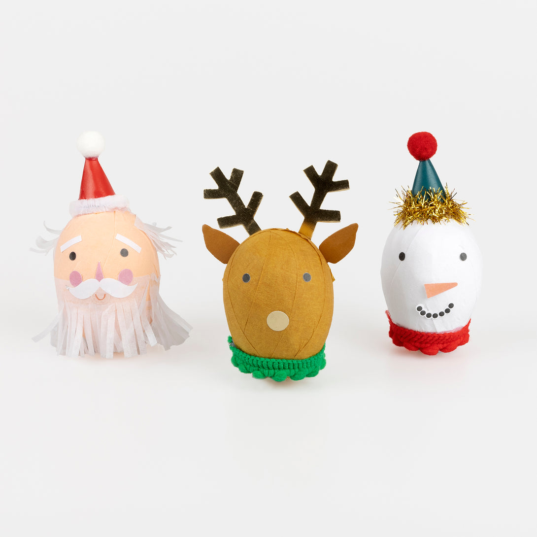Our surprise balls, in the shape of Santa, a snowman and a reindeer, contain a gold party hat, 2 stickers, a joke and a fun eraser. Image1