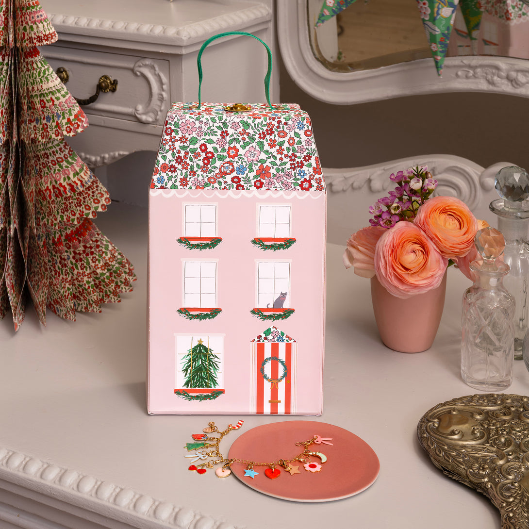 Our luxury advent calendar is designed as a suitcase-style box, with Liberty floral print details, inside which is a bracelet and charms Image2