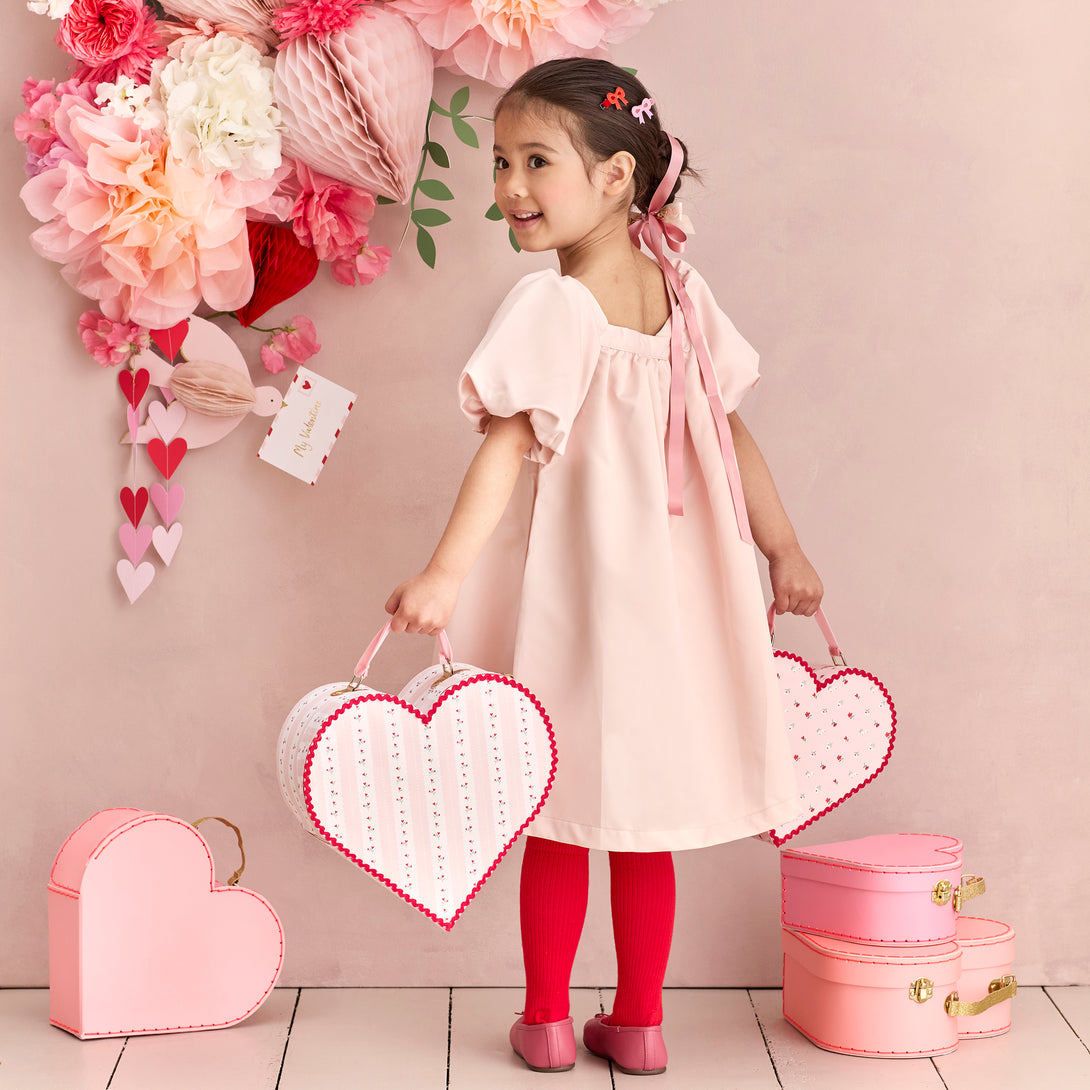 Our kids accessories feature heart suitcases in pink, red and white with soft velvet handles.