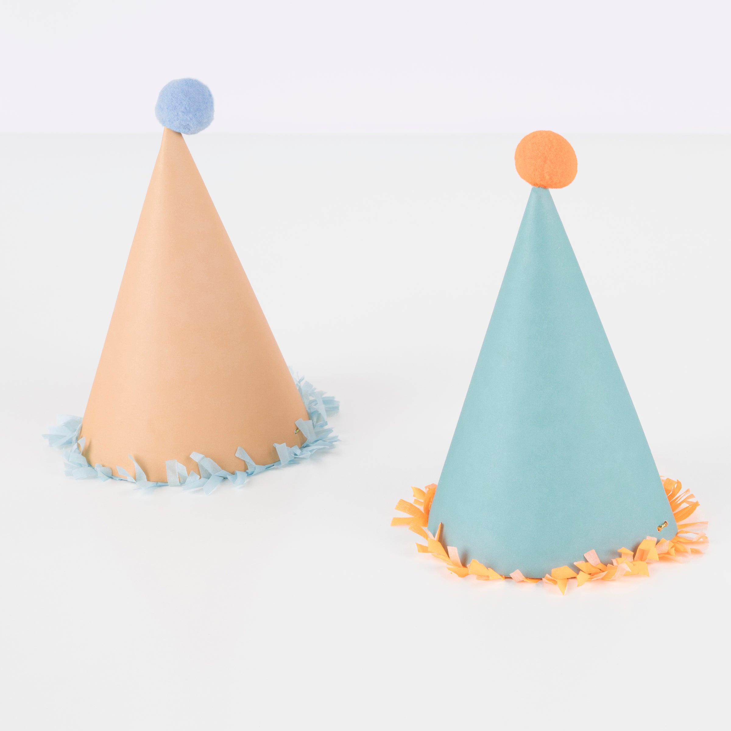 Our paper hats feature fringing, pompoms and bright colours.