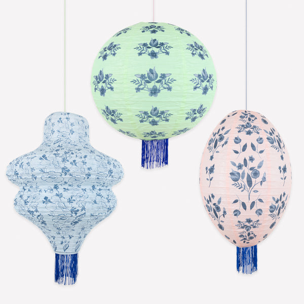 Our paper lanterns set, of three, come in mint, blue and pink, with round, wavy and oval shapes, with blue botanical illustrations and blue tassels. Image1