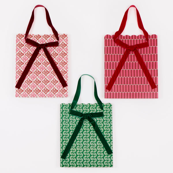 Our medium Christmas gift bags, made from premium paper, feature Molly Mahon block print designs with velvet bows and handles. Image3