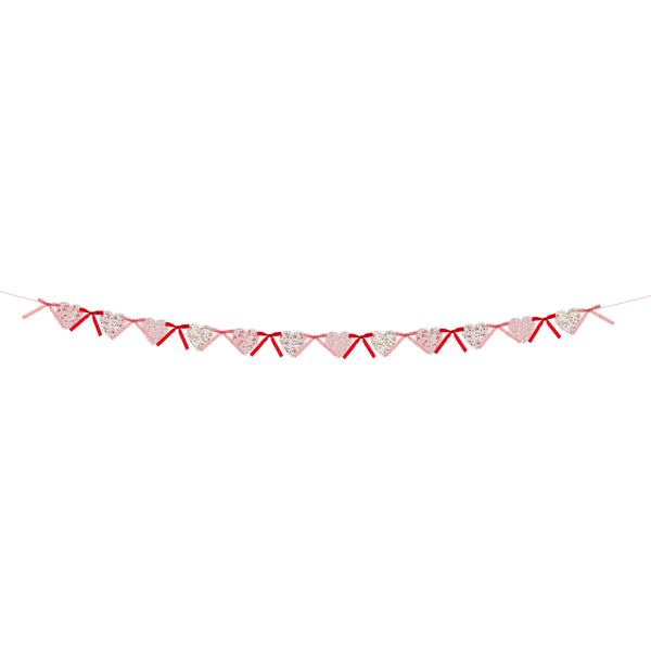 Our Valentine's Day garland feature paper hearts with floral Liberty print designs and pink and red luxe velvet bows. Image5