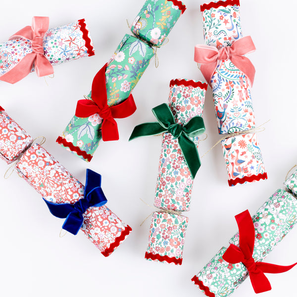 Our stunning luxury Christmas crackers feature joyful Liberty prints and velvet bows, with a selection of gifts inside, and no-snap for a silent pull. Image5