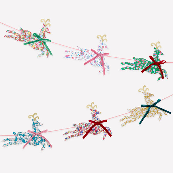 Our Christmas garland, featuring paper reindeers with elegant Liberty print designs and velvet ribbon bows, is perfect to reuse year after year. Image1