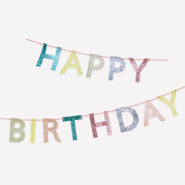 Our glitter garland features the words Happy Birthday in bright colours, with a pink velvet hanging ribbon, packaged in a fabric bag. Image1