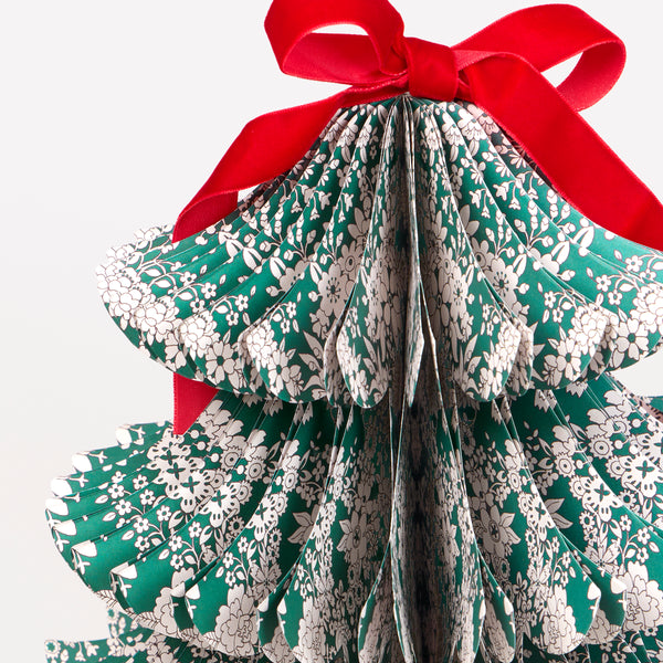 Our decorative Christmas trees, made in 3D shapes from honeycomb paper, feature beautiful Liberty print designs and red velvet bows on top. Image2