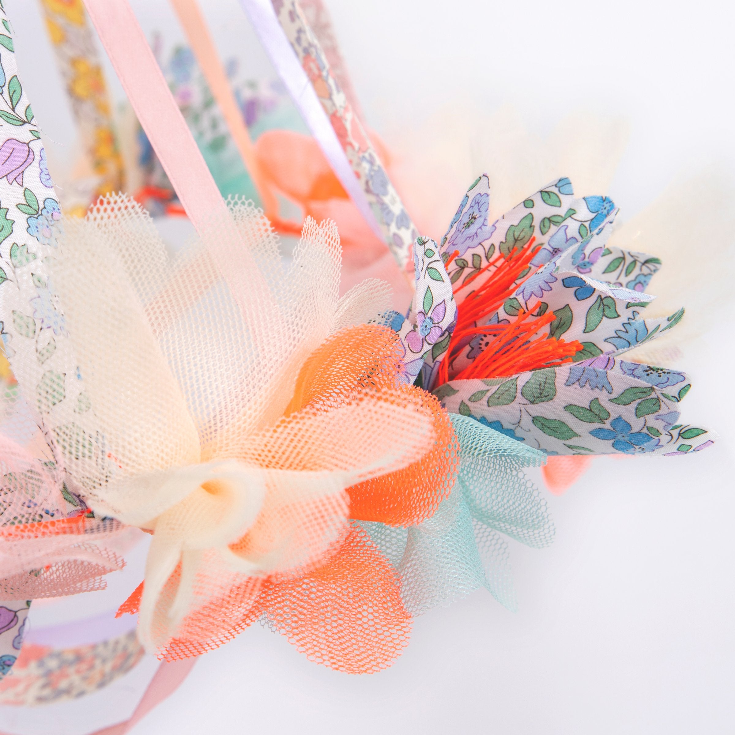 This hanging flower decoration is made from colourful fabric with streamers.