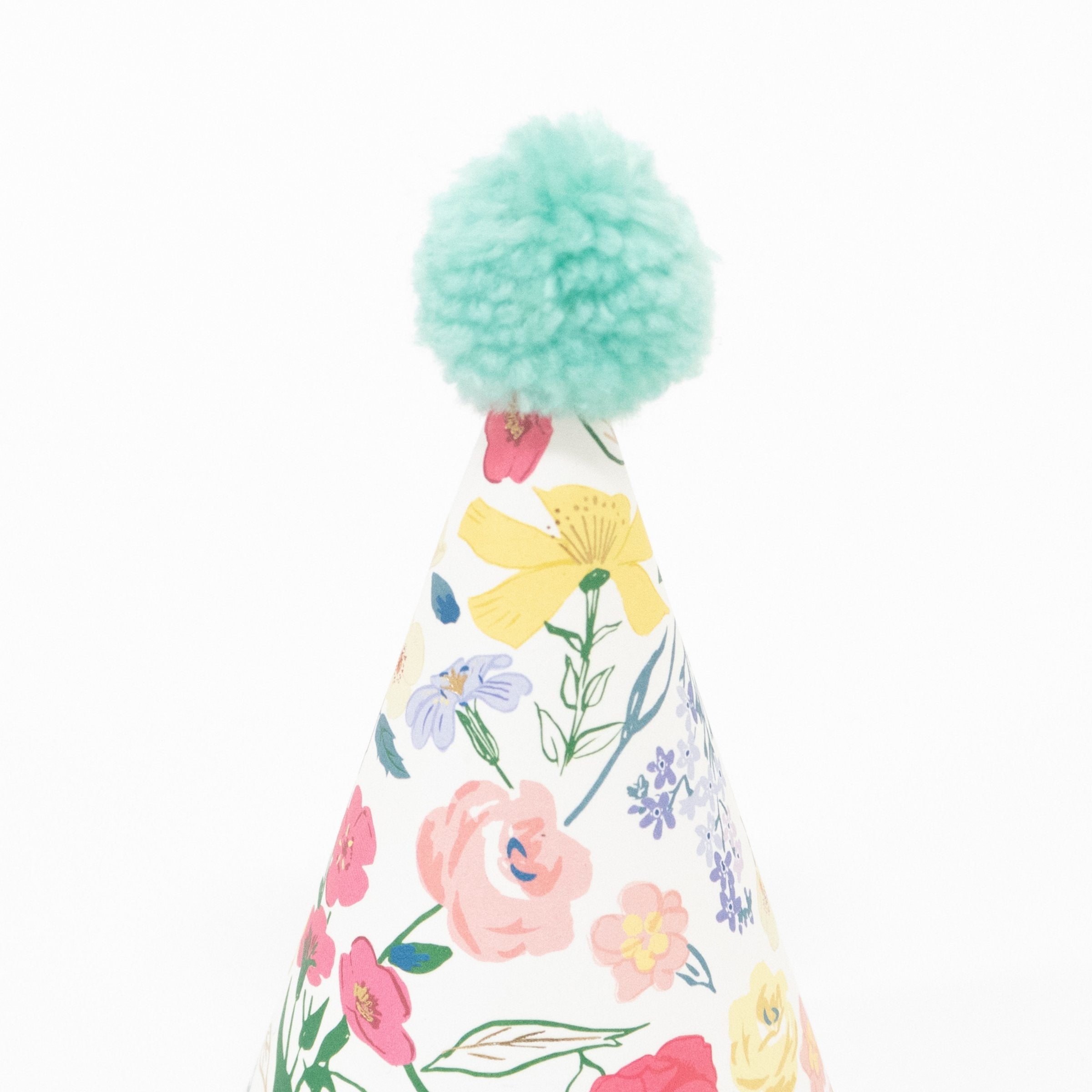 Make your party guests look amazing with our paper hats with floral designs and bright pompoms.