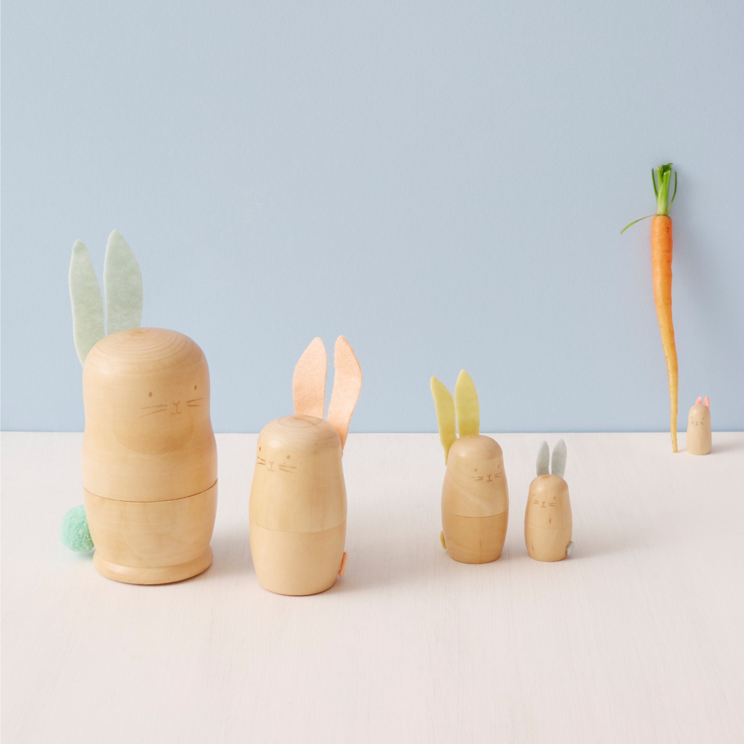 These stacking bunnies are crafted from wood, with gold features, and felt ears and tails.