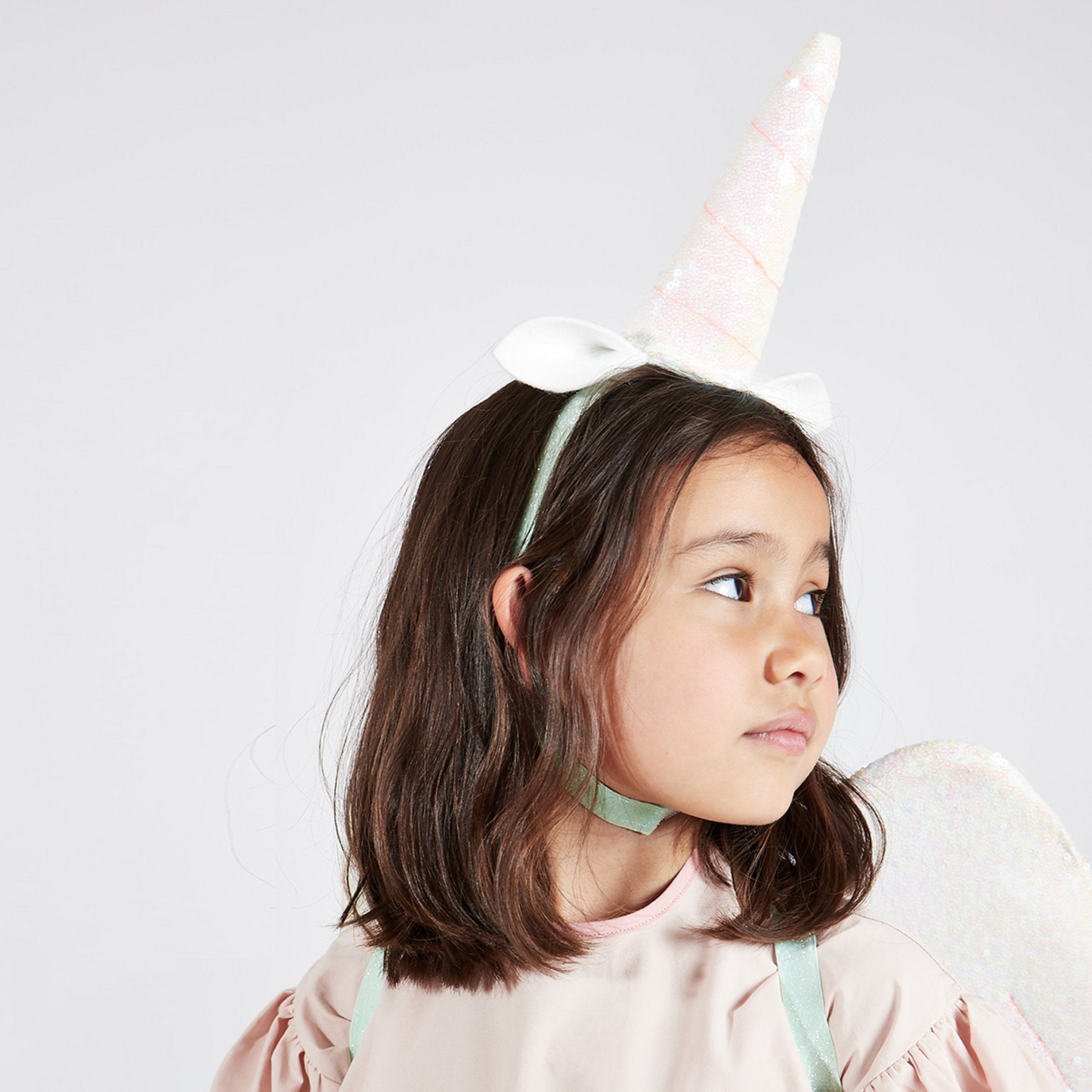 The glittery wings and unicorn headdress are crafted from pink iridescent glitter sequin fabric, with ribbon tassles.
