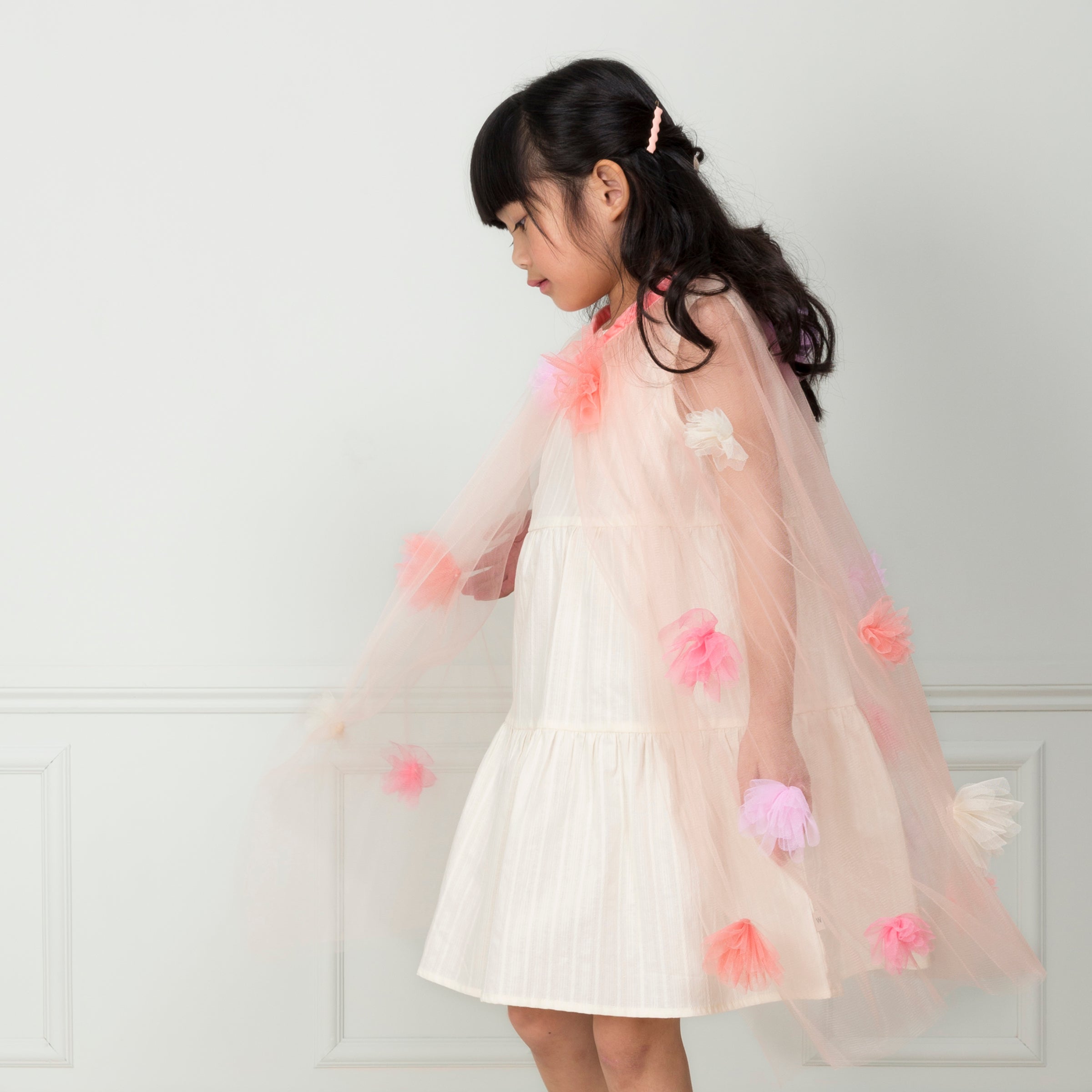 Our kids cape is crafted from tulle with tulle flower embellishments.