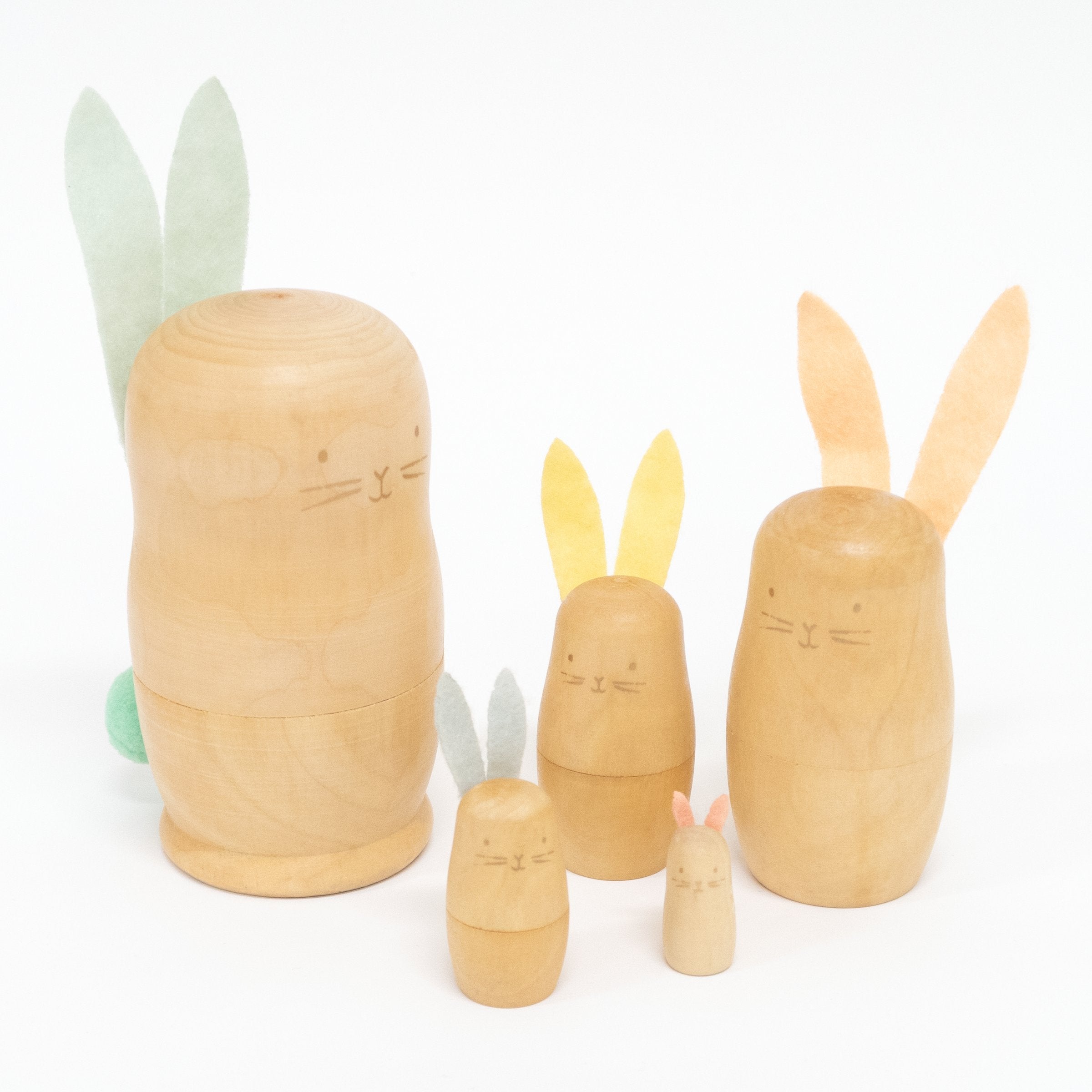These stacking bunnies are crafted from wood, with gold features, and felt ears and tails.