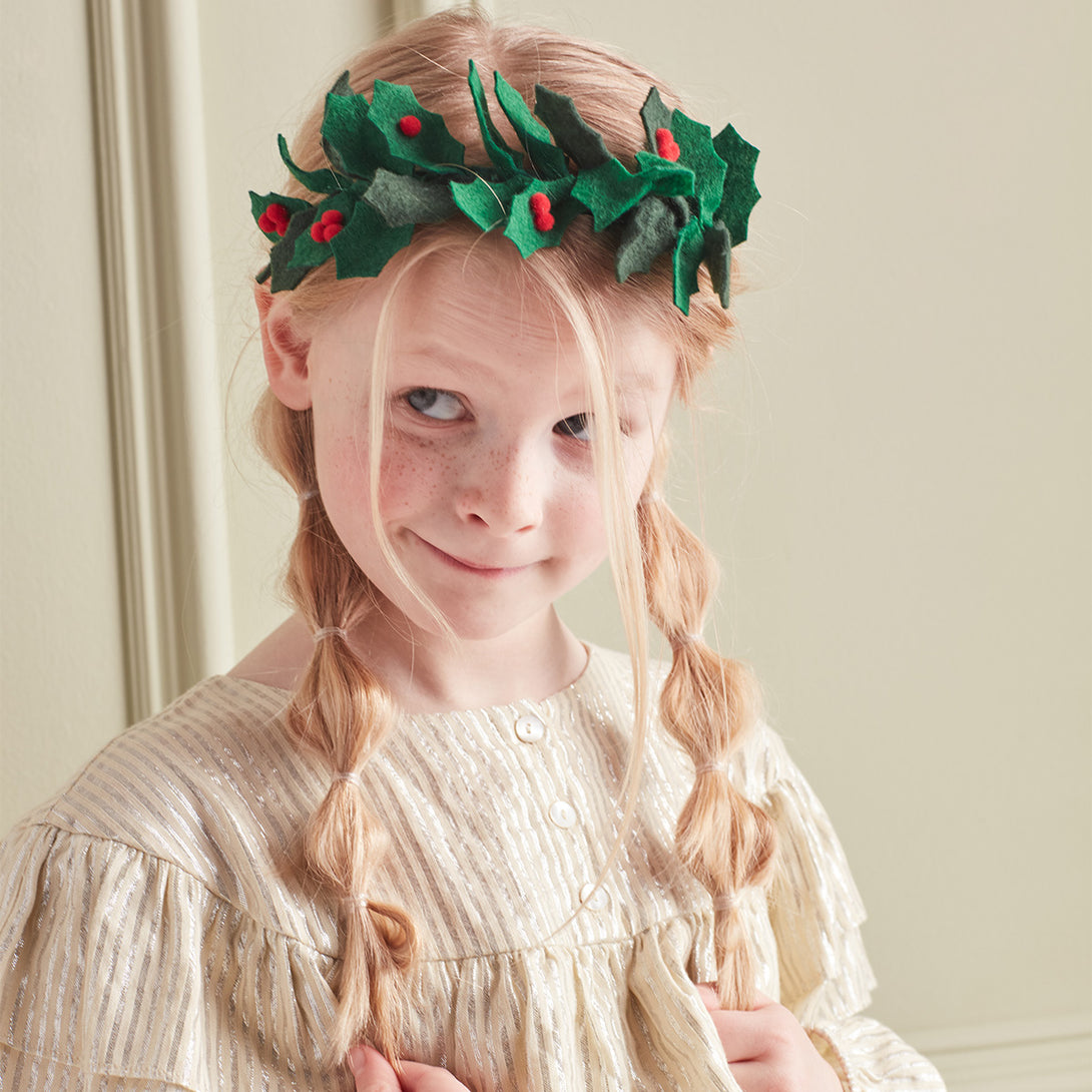Our beautiful Christmas headband is made with felt leaves, pompom berries and a band wrapped in green gingham ribbon.