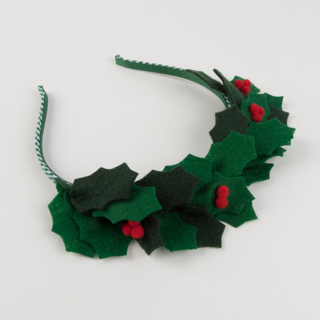 Our beautiful Christmas headband is made with felt leaves, pompom berries and a band wrapped in green gingham ribbon.