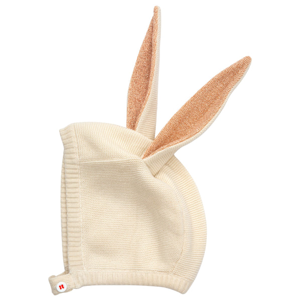 This organic cotton bunny bonnet has a shimmering peach inner on the ears, and an ivory coloured button fastening. Image5