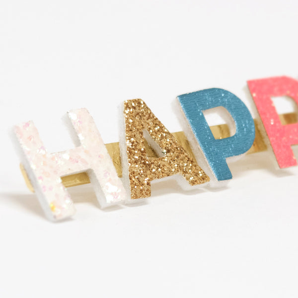 Our gold hair clip features the word "Happy" in leatherette and glitter lettering. Image2